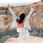 happy adult woman raising hands mountain